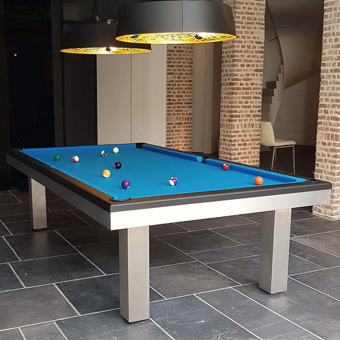 Bright blue felt pool table placed in a rustic-modern interior with exposed brick arches and bold lighting.