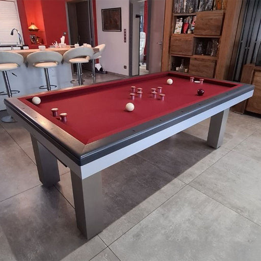 Red cloth Full Loft Design pool table in a modern home setting with bar stools and warm wooden cabinetry.