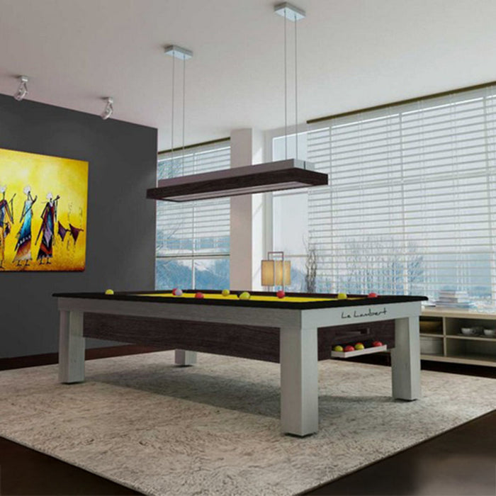 Premium Billards Toulet Lambert Competition Pool Table in dark wood finish, set in a chic lounge with panoramic windows and a warm ambient light.