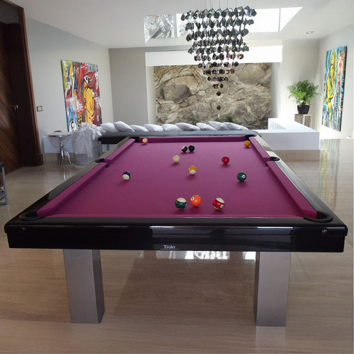 Glossy black frame pool table with striking magenta felt in a vibrant, art-filled contemporary interior.