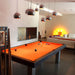 Striking orange felt pool table in a luxurious living area with ambient pendant lighting and bold decor.