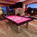 Vibrant pink billiards table in a stylish evening lounge with panoramic views and modern lighting.