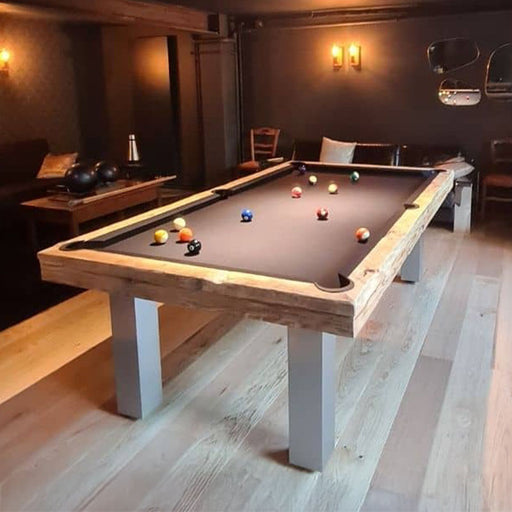 Chic entertainment room with Billards Toulet Megeve pool table in black cloth and brushed steel legs, surrounded by cosy seating.
