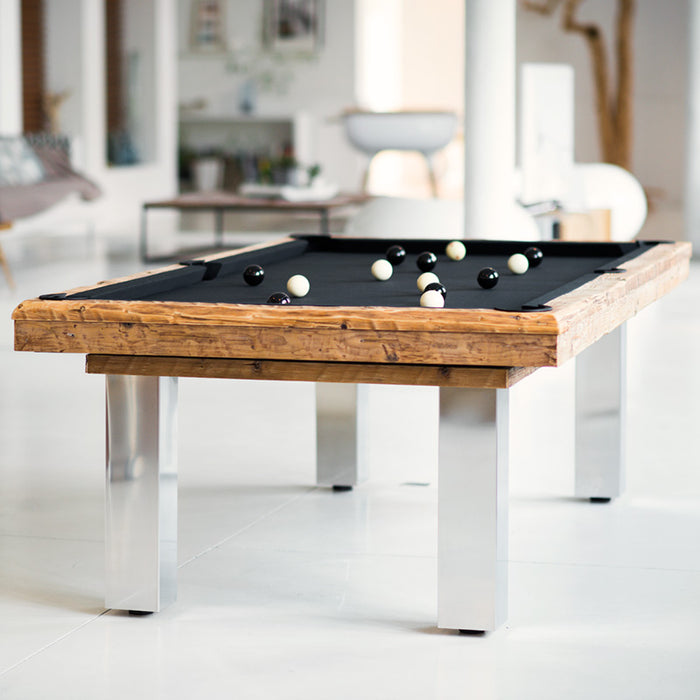 Sleek and modern Billards Toulet Megeve pool table in black felt and chrome legs, placed in a bright open-plan contemporary loft.