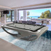 Elegant white Billards Toulet Whitelight pool table with blue playing surface in an artistic space with curved architecture and creative wall mural.