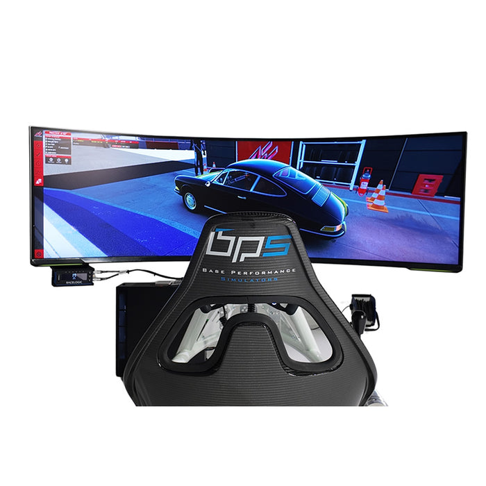 BPS Blade Racing Simulator rear view showing BPS-branded carbon fibre seat and large curved ultrawide monitor displaying Assetto Corsa