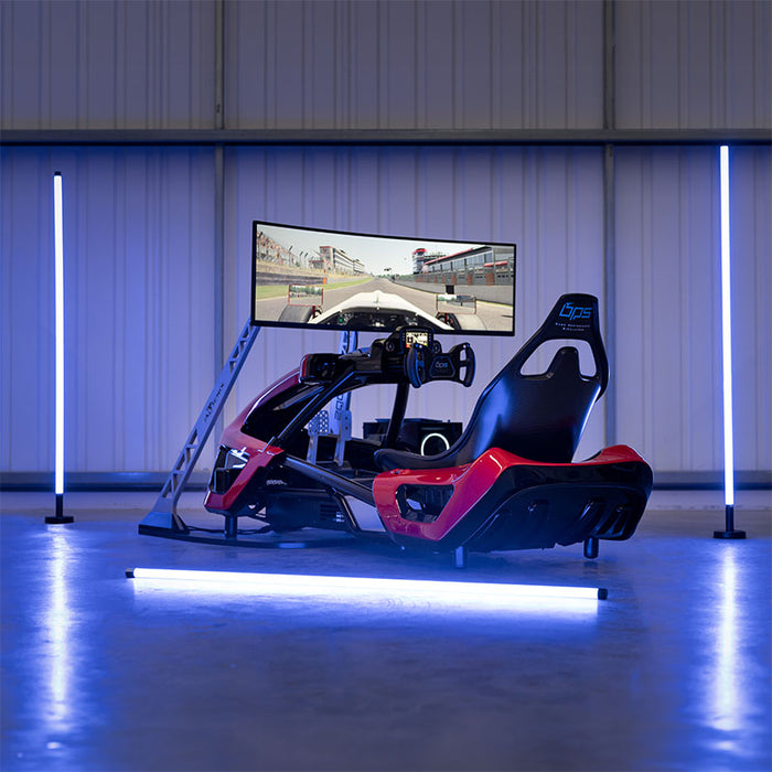 BPS Phoenix Commercial Racing Simulator in a full F1-style red and black cockpit with curved ultrawide display, photographed in a professional hangar environment with blue LED ambient lighting