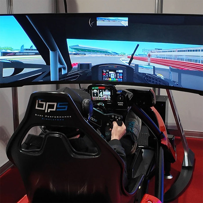 BPS Phoenix Commercial Racing Simulator three-quarter rear-right angle in hangar with white LED strips showing full chassis profile and active screen