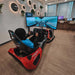 BPS Phoenix Commercial Racing Simulator at exhibition with driver seated in side profile view, racing on active curved display