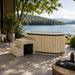 Celsium Aiste Ice Bath Grand in a natural wood finish with integrated steps overlooking a lake, luxury outdoor cold plunge for ice bath recovery, wellness and relaxation.
