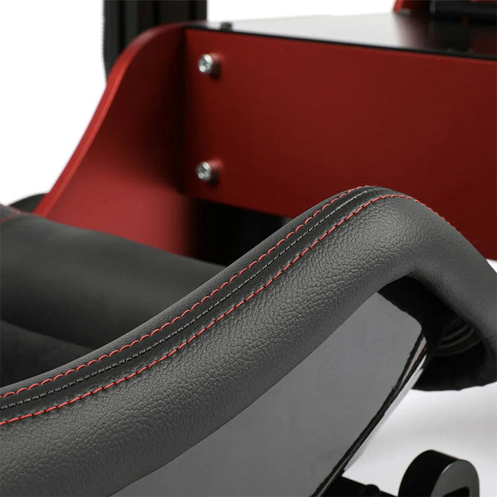 Cool Performance Formula Pro Racing Simulator black leather seat bolster macro close-up showing double red contrast stitching detail with red powder-coated chassis panel in background.