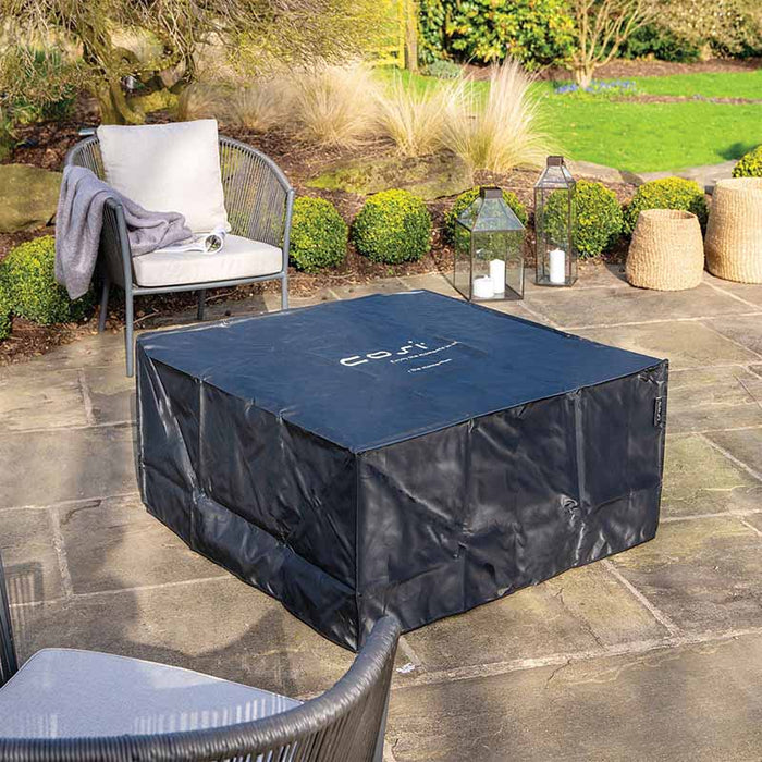 The Cosiloft 100 Fire Pit Table covered with an all-weather protection cover in an outdoor setting.