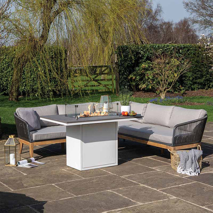 The Cosiloft 120 Relaxed Dining Fire Pit Table in a garden setting, surrounded by comfortable outdoor furniture, perfect for cosy evenings.