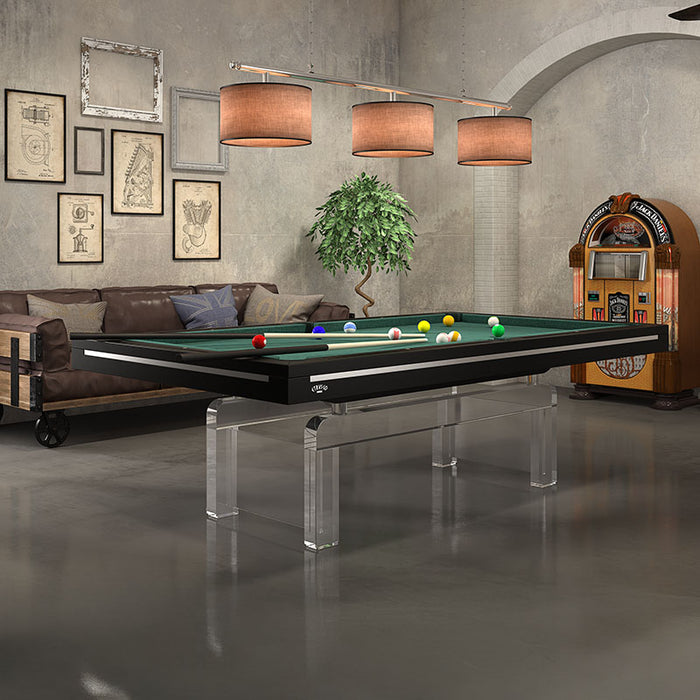 Modern Etrusco Contemporaneo pool table with black frame and green felt, featuring clear acrylic legs in a stylish loft space.