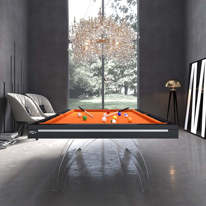 Etrusco P40 pool table in matte black frame with vibrant orange cloth and clear acrylic legs, placed under a grand chandelier in a striking monochrome-themed interior.