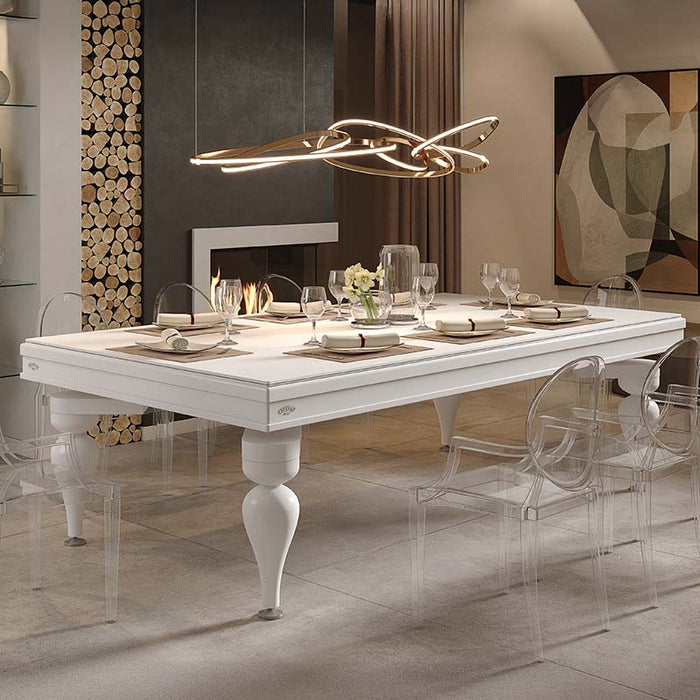 Etrusco Smile pool table converted into a white dining table with bold legs and clear chairs, set in a contemporary room with fireplace.