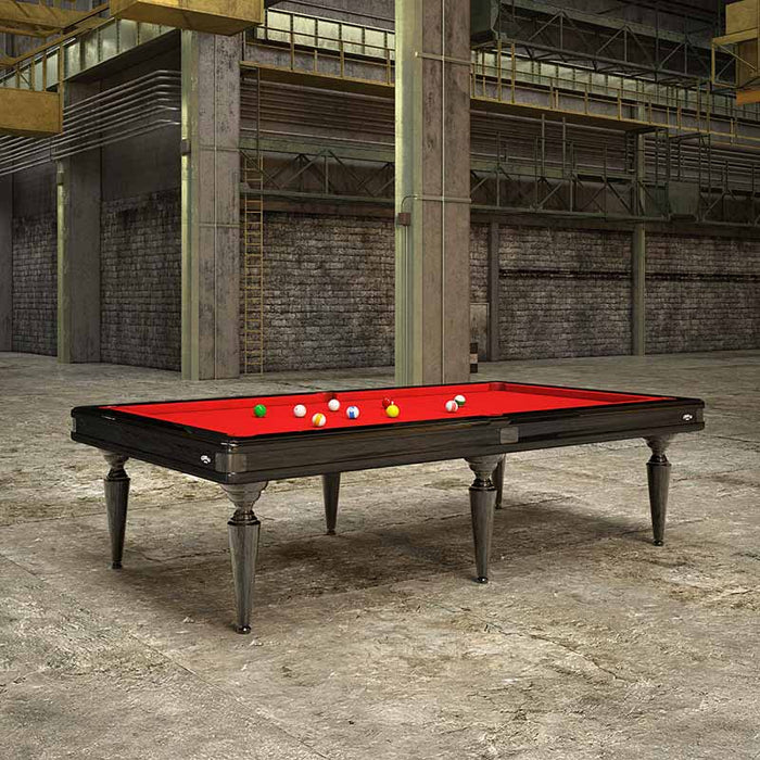 Etrusco Smile pool table in an industrial loft with black frame and red cloth, placed against a raw concrete and brick backdrop.
