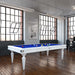 Modern Etrusco Smile pool table with a white frame and blue cloth, placed in a loft-style room with rich wooden flooring.