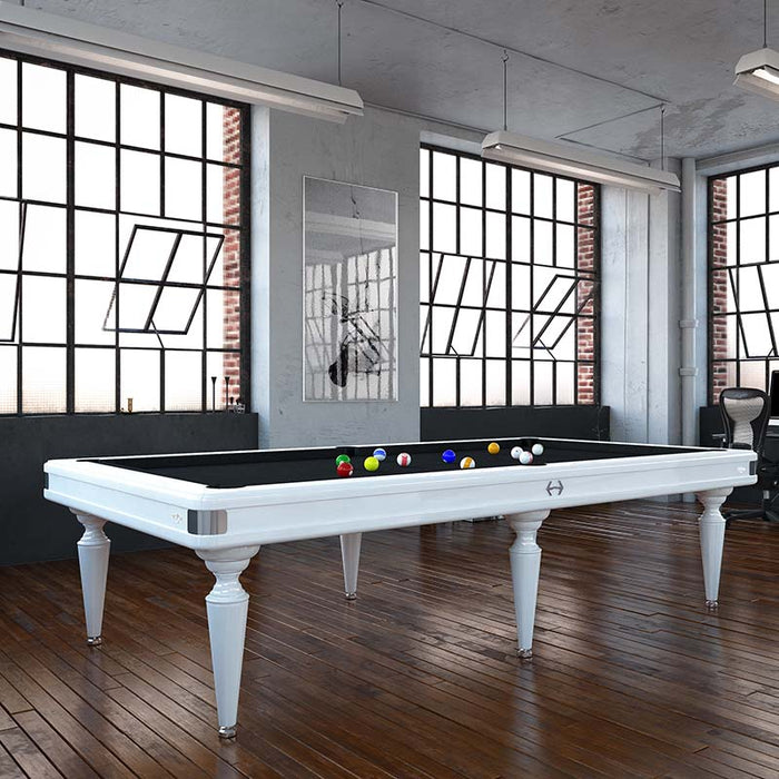 Minimalist Etrusco Smile pool table in white finish with black cloth, featured in a bright industrial loft with urban character.