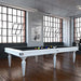 Minimalist Etrusco Smile pool table in white finish with black cloth, featured in a bright industrial loft with urban character.