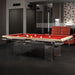 Etrusco Top pool table with red felt and light wood frame, supported by transparent acrylic legs in a sleek, modern interior with dark flooring.