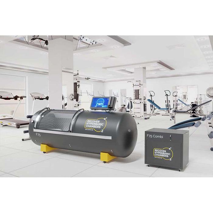 Left angled view of Recover F75 steel hyperbaric chamber in gym with equipment.