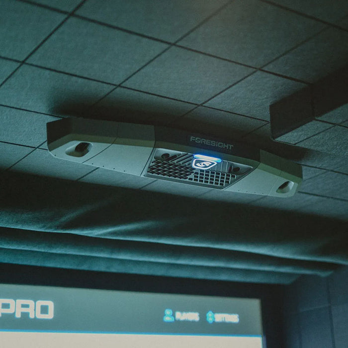 Ceiling-mounted Foresight Falcon golf launch monitor in a virtual golf studio, with LED indicator and advanced motion tracking technology.