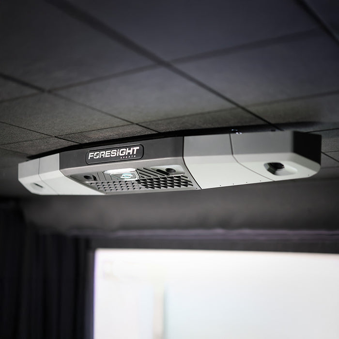 Detailed view of Foresight Falcon overhead golf launch monitor installed on a black ceiling panel, showcasing sensor grid and glowing status light.