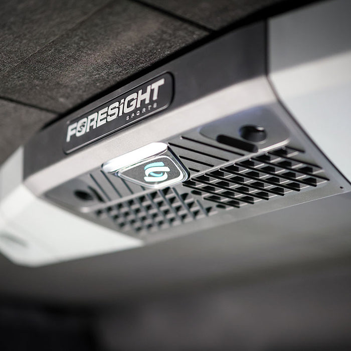 Foresight Falcon overhead launch monitor mounted on dark acoustic ceiling, featuring precision infrared sensors and robust casing.