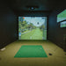 Cosy indoor golf simulator room with Foresight Falcon overhead launch monitor and immersive screen, set in a stylish loft with modern furnishings.