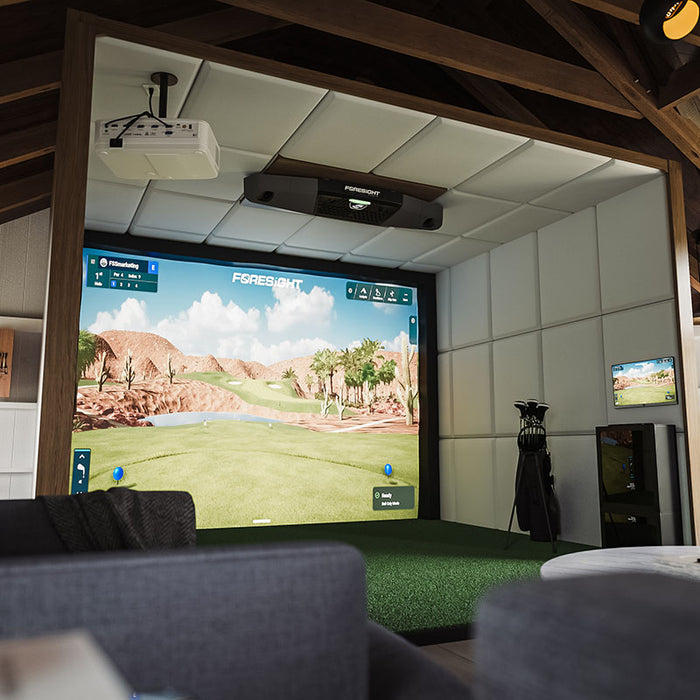 Cosy indoor golf simulator room with Foresight Falcon overhead launch monitor and immersive screen, set in a stylish loft with modern furnishings.