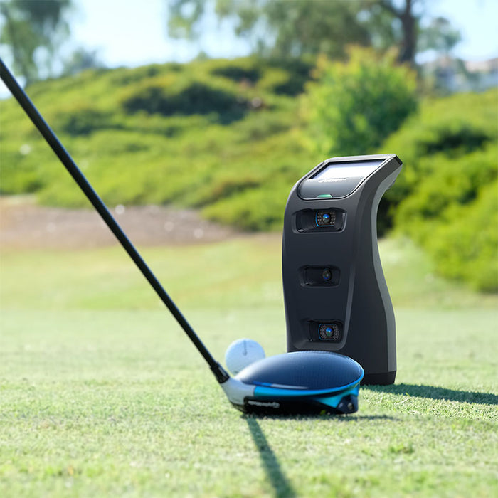 Close-up of golf driver and Foresight GC3 Launch Monitor before tee-off, capturing pre-shot tracking setup.