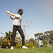 Golfer mid-backswing beside the Foresight GC3 Launch Monitor under clear blue skies on the golf course.