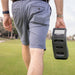 Man carrying Foresight GC3 Launch Monitor by hand across the fairway, emphasising its lightweight design.