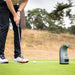 Golfer lining up a putt next to the Foresight GC3 Launch Monitor, showcasing precise shot data capture.
