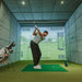 Golfer mid-backswing in indoor simulator bay using Foresight GC3S Launch Monitor for detailed swing and ball flight metrics.