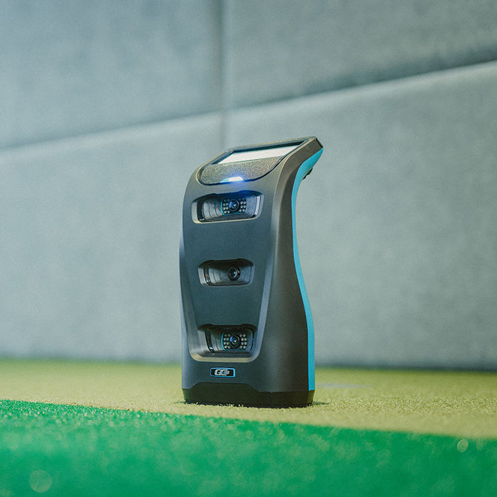 Foresight GC3S Launch Monitor standing on green turf indoors, showcasing its three high-speed camera sensors and angled touchscreen.