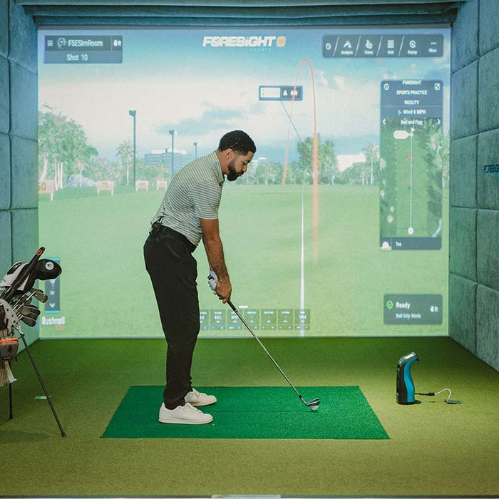 Golfer lining up golf shot in simulator using Foresight GC3S Launch Monitor for accurate indoor swing and ball data.