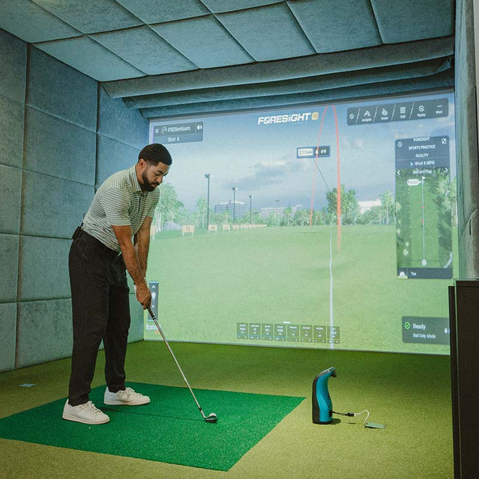 Golfer setting up for swing in simulator bay using Foresight GC3S Launch Monitor for real-time golf shot analysis and feedback.
