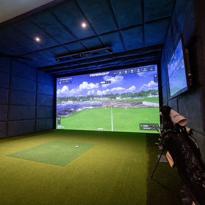 High-end golf simulator bay featuring Foresight GCHawk launch monitor and play-compete-improve interface projected on screen.
