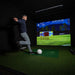 Man playing virtual football using the Foresight GCHawk overhead launch monitor in a dark indoor simulator setup, showcasing multi-sport tracking accuracy and immersive gameplay experience.