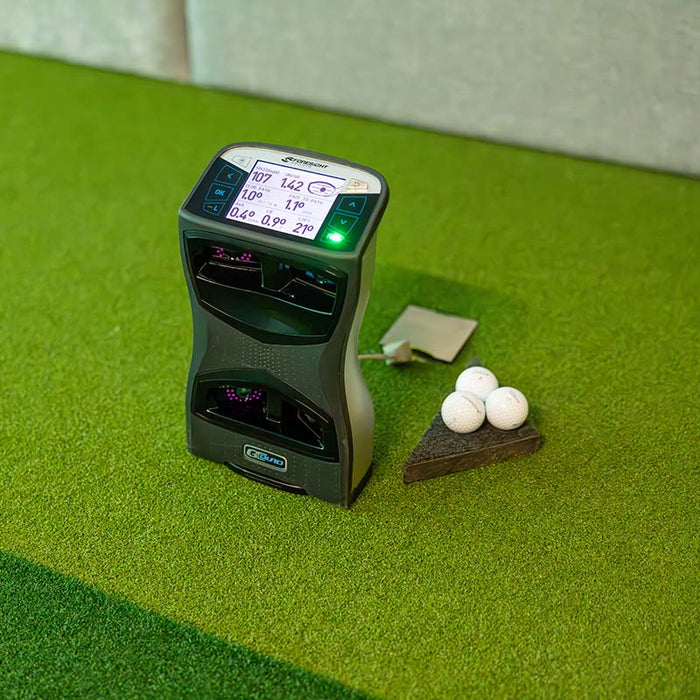Foresight GCQuad launch monitor placed on an indoor green next to golf balls, ready for precise data collection during practice.