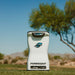 Front view of the Foresight QuadMAX Launch Monitor on grass with a desert tree background.