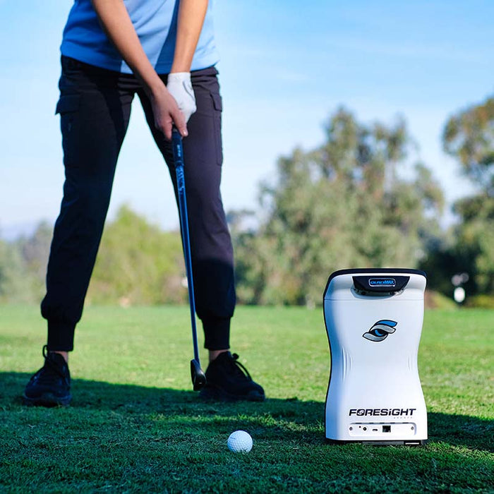 Golfer preparing to swing with the Foresight QuadMAX launch monitor set up on the fairway for accurate swing and ball flight tracking.