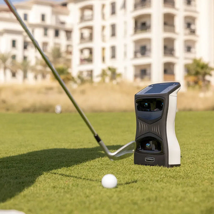 Golfer preparing to swing with the Foresight QuadMAX Launch Monitor beside the golf ball on course.