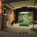 Luxury garage golf simulator setup with Foresight Sim-in-a-Box, featuring realistic virtual fairway, projector, and professional golf bags for home training.