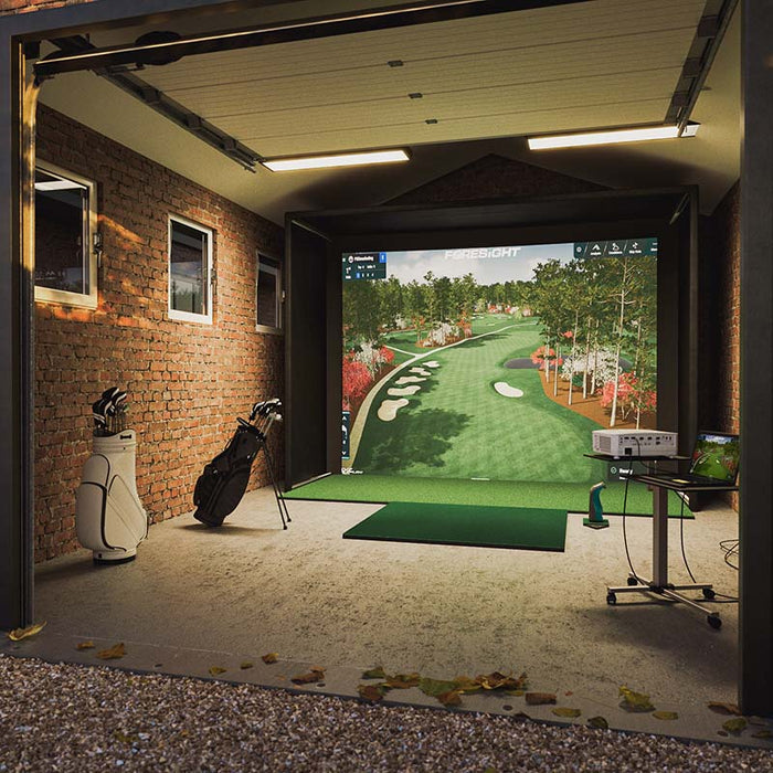 Foresight Sim-in-a-Box Play Golf Simulator installed in a rustic brick garage with golf bags, projector setup, and realistic fairway display.