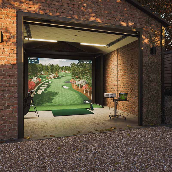 Side-angle view of Play Golf Simulator by Foresight, integrated into a converted brick outbuilding, showing projection system and open garage door.