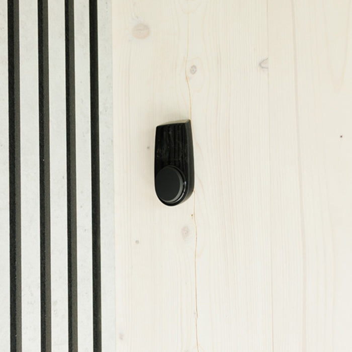 Close-up of temperature and humidity sensor in Geneva St. Moritz sauna, mounted on natural wood panel for climate control.