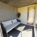 Cosy Geneva St. Moritz outdoor sauna terrace with sofa, frosted door, and full-height glass wall overlooking landscape.